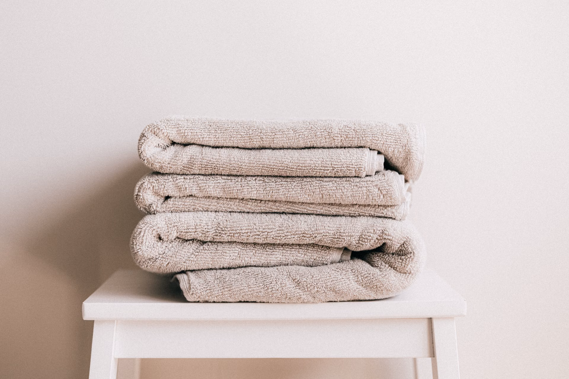 Neatly folded towels stacked on a stool